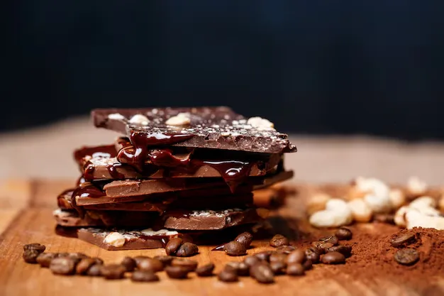 dark chocolate with nuts placed on a wooden table.