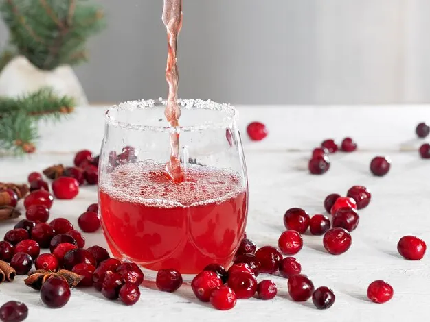 cranberry juice is being poured in a glass.