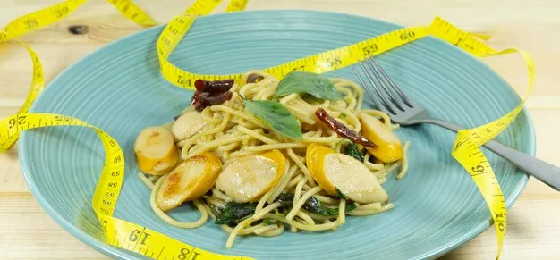 pasta in a blue plate with measuring tape, indicating the impact of pasta on weight loss.
