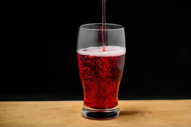 dr pepper drink pouring into a glass.