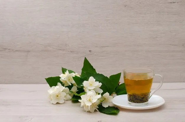 jasmine flowers placed at the side of a green tea cup.
