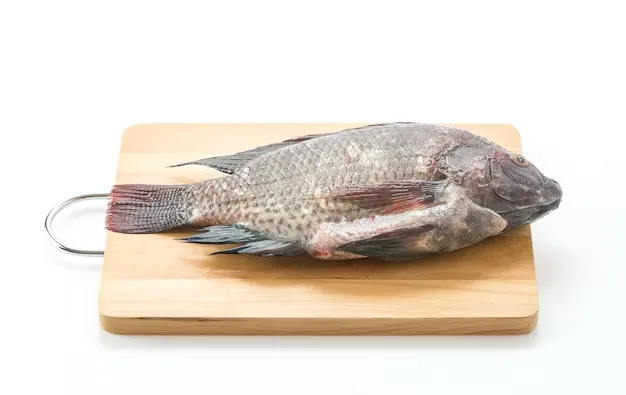 black tilapia on a wooden cutting board
