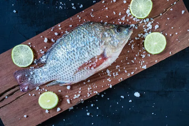 tilapia with lemon slices on the wooden surface