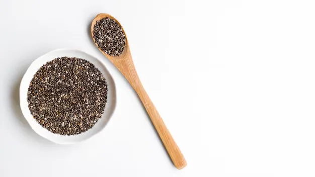 sesame seeds in a small bowl and wooden spoon