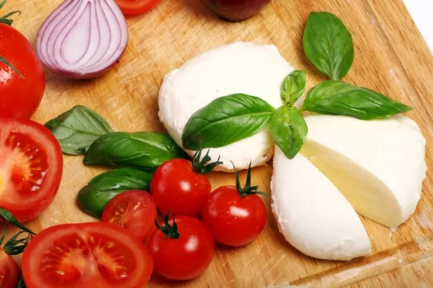 mozzarella cheese with tomatoes on a wooden board